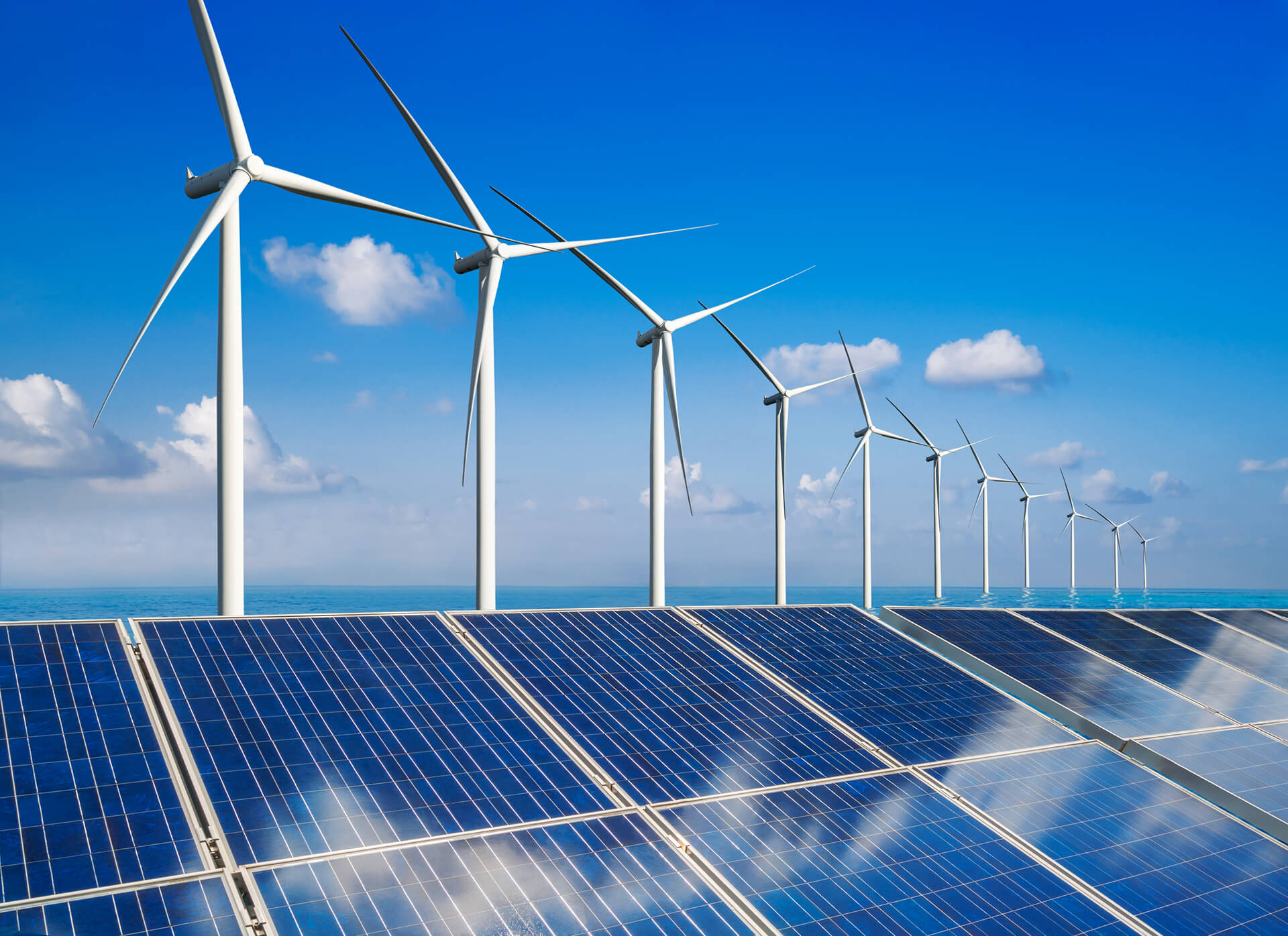 Feature image showing a side-by-side comparison of solar PV panels and a wind turbine against a clear blue sky, symbolizing the choice between solar and wind energy for renewable power solutions.